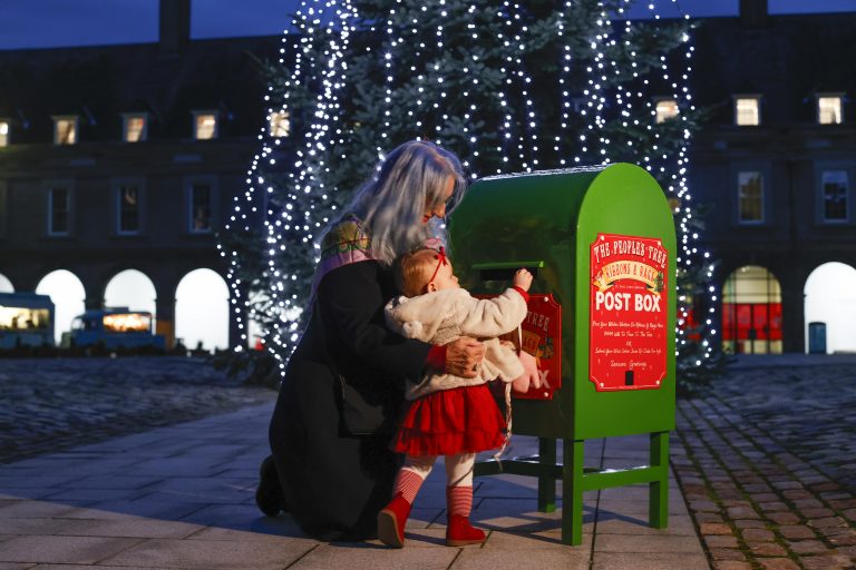 The People’s Tree, pictured at the Irish Museum of Modern Art is Bernadette and Lisa Murphy with Penny Murphy, 17 months, from Inchicore posting their wishes on ribbons that will be tied to the impressive 35ft Christmas tree located in the courtyard